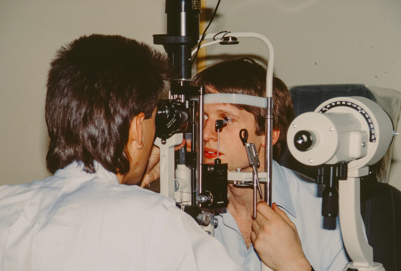 Optometrist examining a patient's eye with equipment